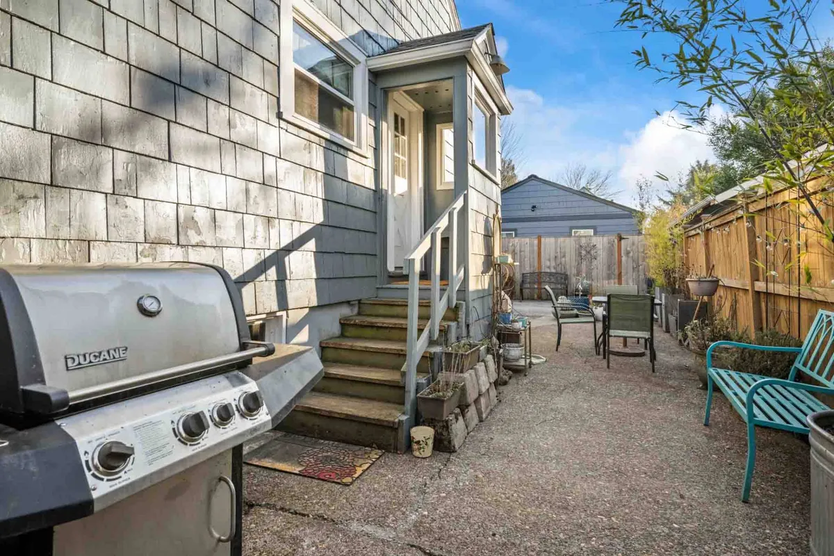 An exterior setting with a grill, staircase leading to the entrance, and an outdoor seating area ready for socializing. It exudes a casual, communal mood perfect for gatherings, relaxing, or enjoying quick bites before heading out.